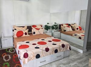 a bedroom with two beds with red flowers on them at Ram in Piteşti