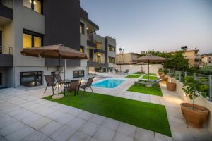 a patio with a table and chairs and a pool at AORA Asites Mountain View in Kato Asites