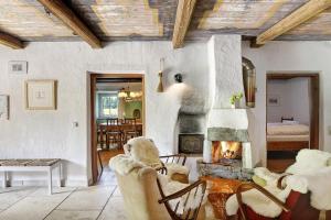 a living room with a fireplace and chairs and a table at Ferienhaus Stadlerhof in Rettenschöss
