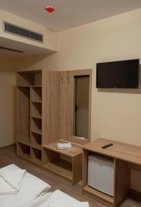 ein Zimmer mit einem Schreibtisch und einem Fernseher an der Wand in der Unterkunft Urusossziklakert in Dealu