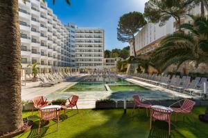 a group of chairs and a fountain in front of a building at Hotel Vibra Beverly Playa in Paguera