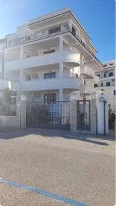 a white building with a gate in front of it at Appartamenti Bramante in Vieste