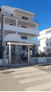 a white building with a gate in front of it at Appartamenti Bramante in Vieste