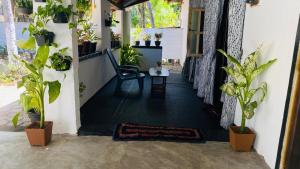 a hallway with a chair and potted plants at JA Villa in Pottuvil