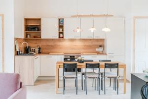 a kitchen with a wooden table and chairs at Grain d'Or - Proche Noirmoutier - Jardin in Bouin