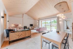 a living room with a table and a dining room at Grain d'Or - Proche Noirmoutier - Jardin in Bouin