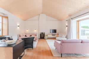 a living room with pink furniture and a large window at Grain d'Or - Proche Noirmoutier - Jardin in Bouin