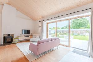 a living room with a pink couch and a large window at Grain d'Or - Proche Noirmoutier - Jardin in Bouin +19 photos