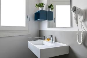a bathroom with a white sink and a phone at Aurà Guest House Iblea in Ragusa +53 photos