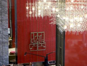 a red wall with a chandelier in a restaurant at HUALUXE Beijing Xinan in Beijing