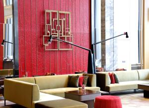 a living room with couches and a red wall at HUALUXE Beijing Xinan in Beijing