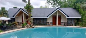 a house with a swimming pool in front of a house at Casa Basilisa Hotel & Resort in Guinobatan
