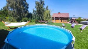 a swimming pool in a yard with chairs and a playground at Wrzosowe Wzgórze in Chęciny