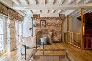 a living room with a brick fireplace and a chair at Old Town - Lovely typical house in Lille