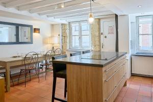 a kitchen with a large island with a table and chairs at Old Town - Lovely typical house in Lille +32 photos