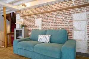 a blue couch in a living room with a brick wall at Old Town - Lovely typical house in Lille