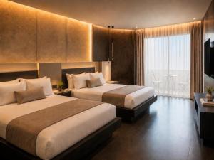 a hotel room with two beds and a balcony at La Coquille - הקונכייה in Eilat