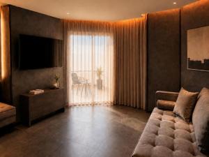 a living room with a couch and a large window at La Coquille - הקונכייה in Eilat