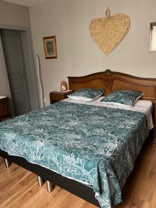a bedroom with a bed with a blue comforter at Elsasslogie im Winzerdorf in Cleebourg