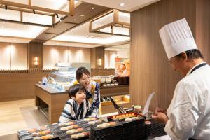 a woman and a child in a kitchen with a chef at Ooedo Onsen Monogatari Premium Ikaho in Shibukawa +8 photos