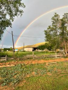 a rainbow in the sky over a field at UYA A-farme in Saty +5 photos