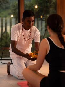 a man holding a plate of food next to a woman at Wishing Tree Boutique Resort and Spa - Haputale's Panoramic Hideaway in Haputale