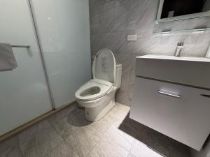 a white bathroom with a toilet and a sink at RenShan Homestay in Taitung City