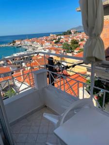 a balcony with an umbrella and a view of a city at Hotel Antonios in Pythagoreio