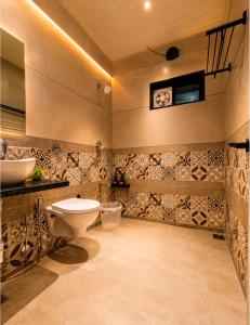 a bathroom with a toilet and a sink at The Boho Peach Villa in Mount Ābu +45 photos