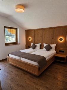 a bedroom with a large bed with a wooden headboard at Alpenchalet Vital in Neustift im Stubaital