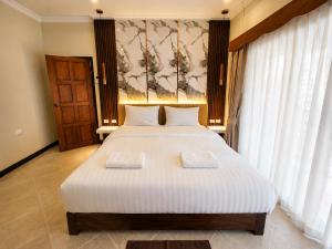 a bedroom with a large bed with two towels on it at Phratamnak Seaside Pool Villa in Pattaya South