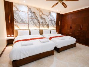 a bedroom with two beds and a painting on the wall at Phratamnak Seaside Pool Villa in Pattaya South +41 photos
