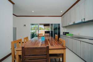 a kitchen with a wooden table and some chairs at Saline Hot Spring Resort นำ้พุร้อนเค็ม รีสอร์ท in Ban Nam Ron (1)