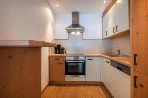 a kitchen with white cabinets and a stove top oven at Alpenchalet Vital in Neustift im Stubaital