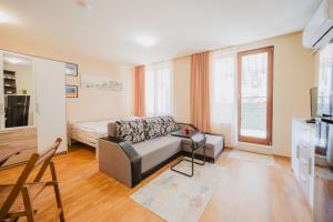 a living room with a couch and a bed at Iglika Beach in Golden Sands +17 photos