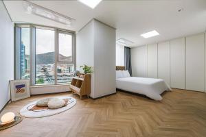 a hotel room with a bed and large windows at Le Collective Busan station in Busan