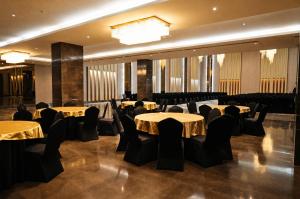 a banquet hall with tables and chairs and a chandelier at ACASA Collective in Aurangabad