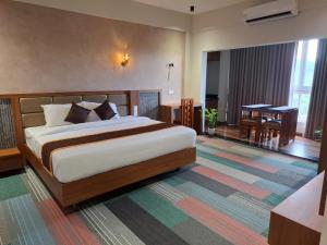 a bedroom with a bed and a table in a room at Windowind Resort in Koroth