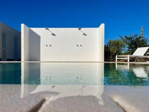 a swimming pool with a white building and water at Masseria Luigi Flora in Ceglie Messapica +52 photos