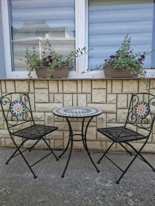 two chairs and a table and two chairs in front of a wall at Apartman BECKER in Đakovo