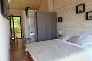a bedroom with a white bed with a wooden wall at La Vilo Dòu Verdon in Roumoules