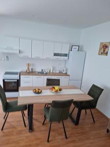 a kitchen with a wooden table with chairs and a tableasteryasteryasteryasteryastery at Apartman BECKER in Đakovo