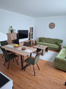 a living room with a table and chairs and a couch at Apartman BECKER in Đakovo