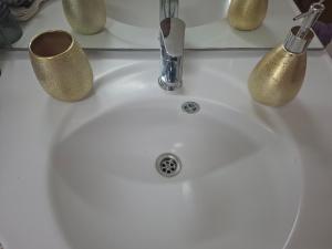 a bathroom sink with two cups and a faucet at Apartman BECKER in Đakovo +11 photos