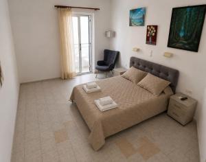 a bedroom with a large bed and a chair at Hotel Antonios in Pythagoreio
