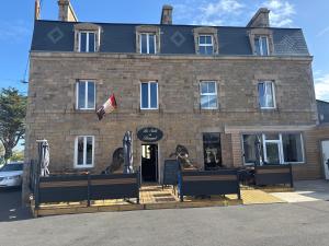 a large brick building with statues in front of it at Chambres côté mer du bouquet in Cosqueville