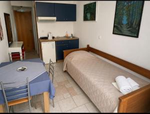 a bedroom with a bed and a table and a kitchen at Hotel Antonios in Pythagoreio +14 photos