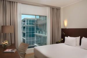 a hotel room with a bed and a large window at NH Savona Darsena in Savona +34 photos