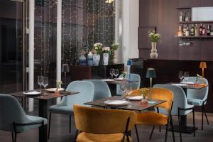 a restaurant with two tables and chairs and flowers at NH Savona Darsena in Savona