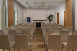 an empty room with rows of chairs and a whiteboard at NH Savona Darsena in Savona